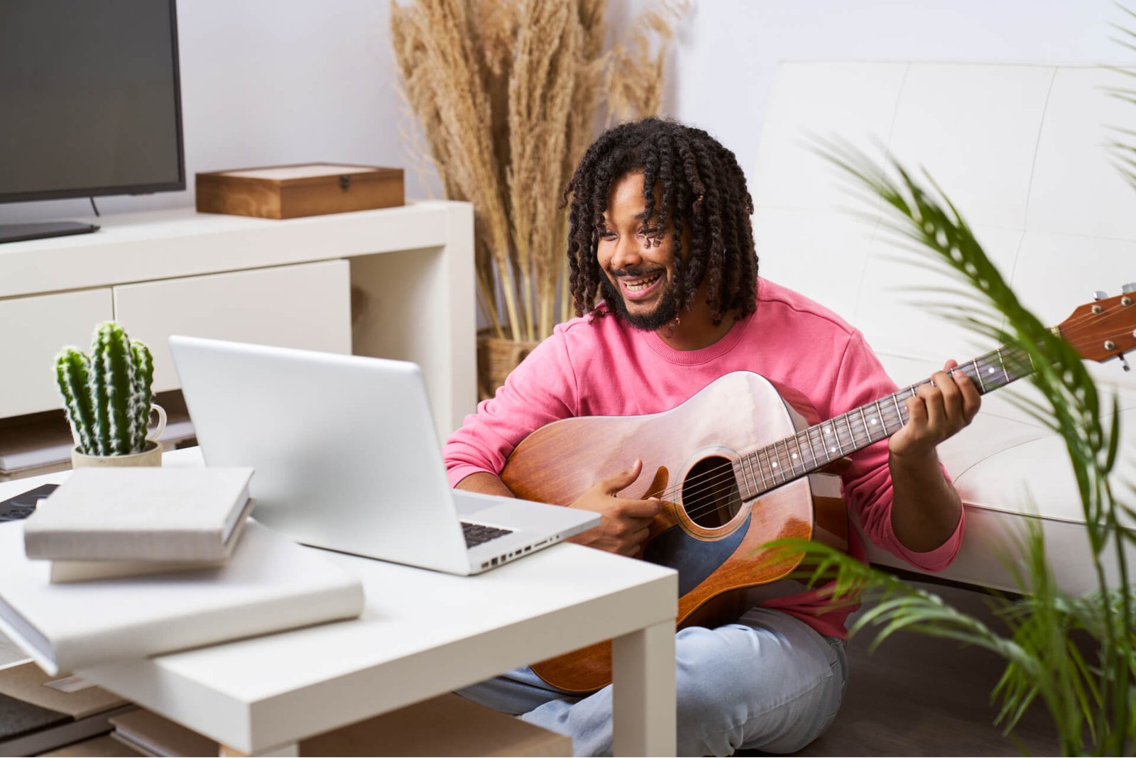 a man in a pink shirt is playing a guitar in a liv 2024 03 21 18 18 58 utc.jpg